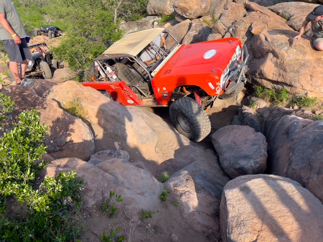 red bronco crawling up rocks