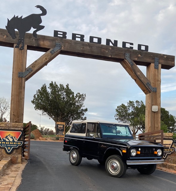 vintage black ford bronco under bronco sign